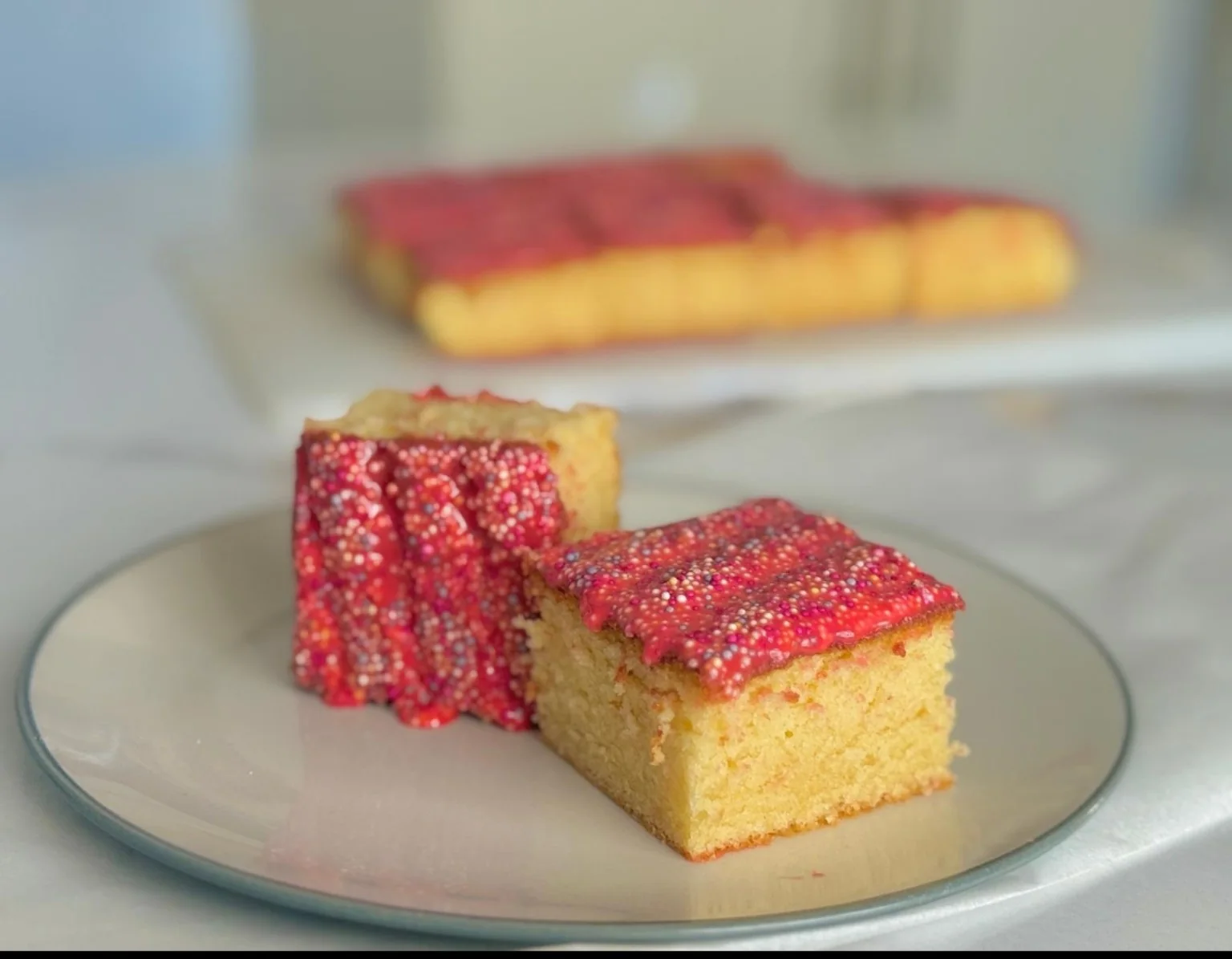 Pink iced tray bake with colourful sprinkles